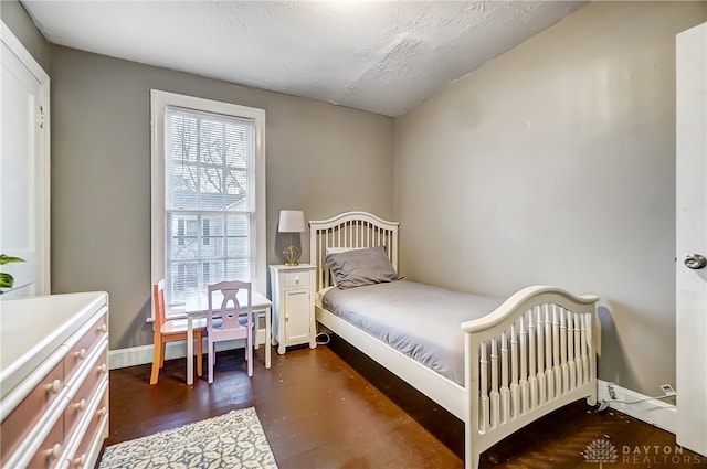 bedroom with dark hardwood / wood-style floors