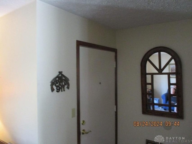 hallway with a textured ceiling