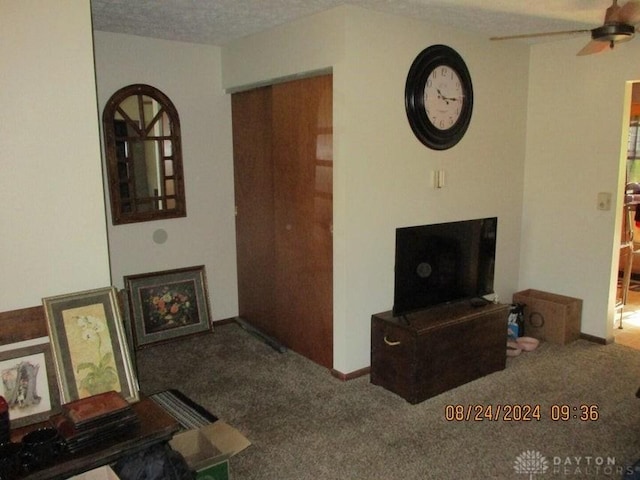 living room featuring carpet, a textured ceiling, and ceiling fan