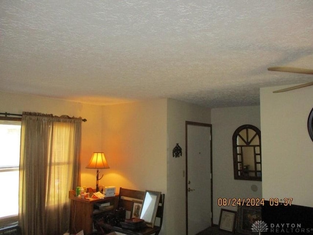 interior space with ceiling fan and a textured ceiling