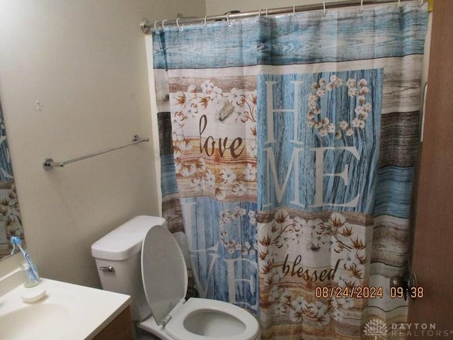 bathroom with a shower with shower curtain, vanity, and toilet