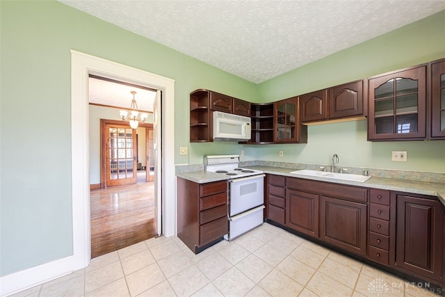 kitchen with an inviting chandelier, sink, a textured ceiling, white appliances, and light tile patterned flooring