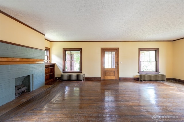 unfurnished living room featuring radiator heating unit, plenty of natural light, and hardwood / wood-style floors