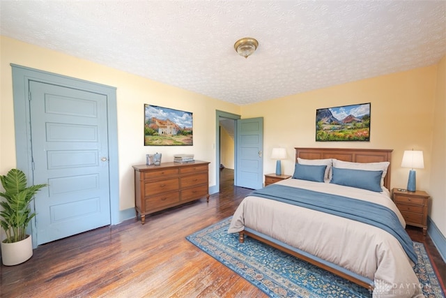 bedroom with hardwood / wood-style floors and a textured ceiling