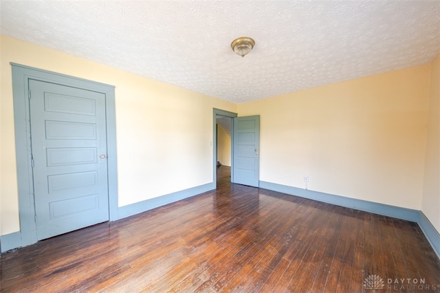 spare room featuring a textured ceiling and hardwood / wood-style flooring