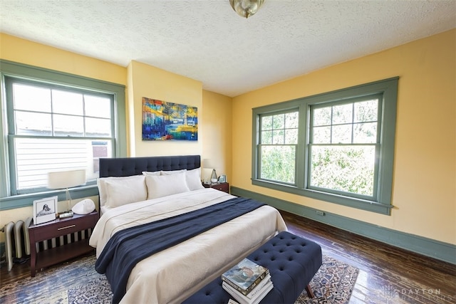 bedroom with dark wood-type flooring and a textured ceiling