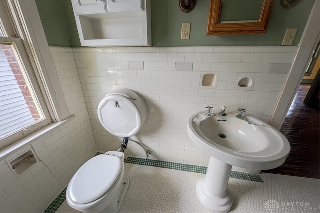 bathroom with tile patterned flooring, tile walls, and toilet