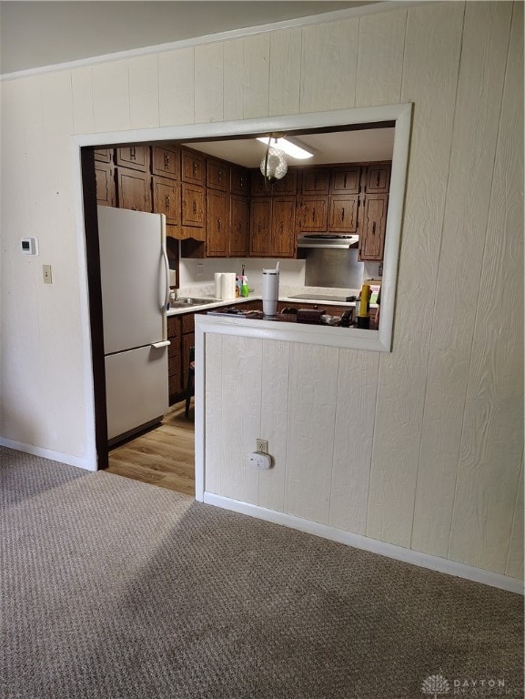 kitchen featuring light carpet and white fridge