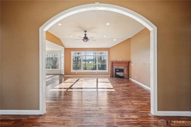 unfurnished living room featuring dark wood-type flooring, ceiling fan, and lofted ceiling