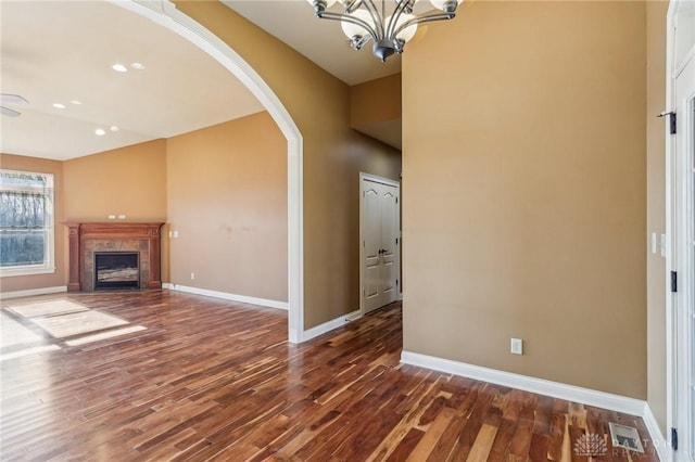 unfurnished living room with an inviting chandelier and dark wood-type flooring