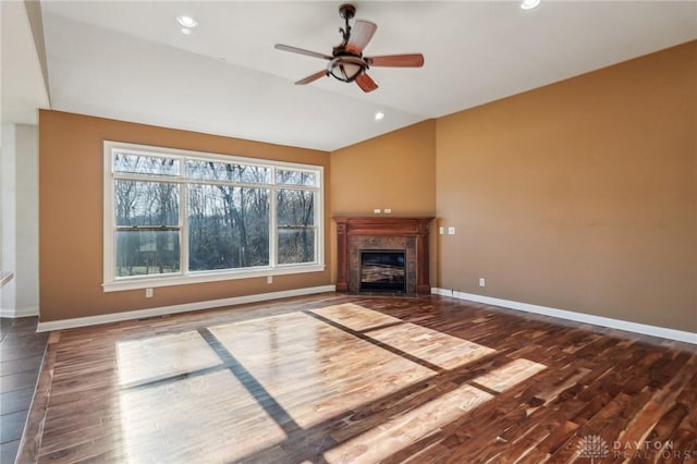 unfurnished living room with ceiling fan, dark hardwood / wood-style floors, and a tile fireplace