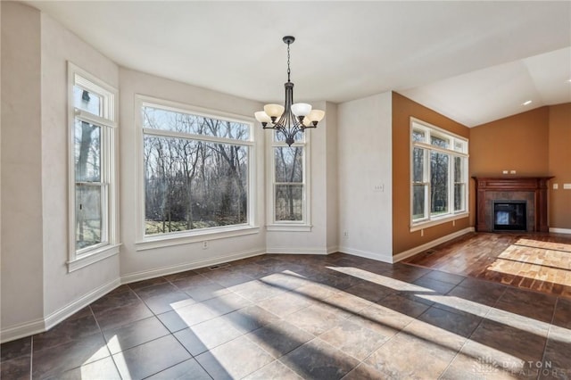 unfurnished dining area featuring a wealth of natural light, vaulted ceiling, and an inviting chandelier