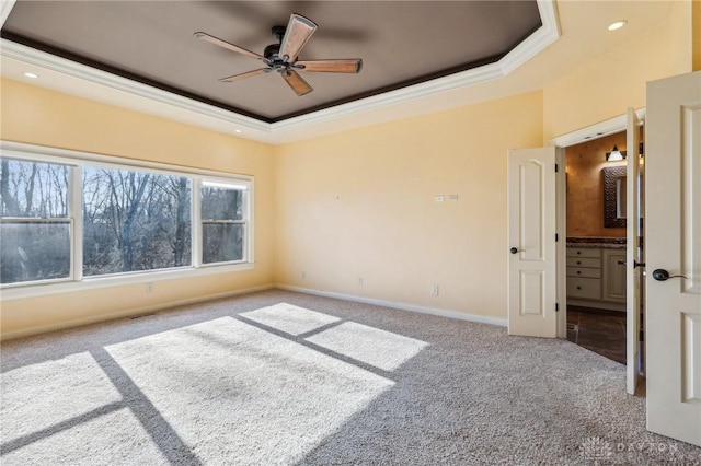 empty room with ceiling fan, a raised ceiling, crown molding, and light carpet