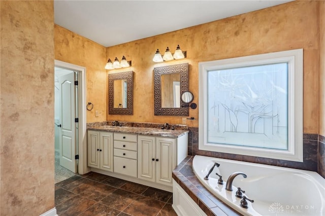 bathroom featuring vanity and tiled tub