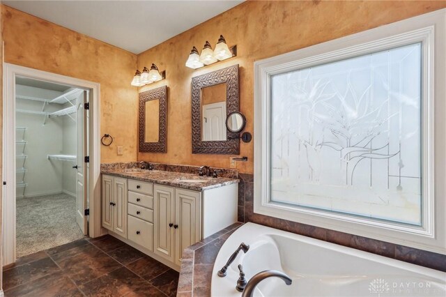 bathroom featuring a washtub and vanity