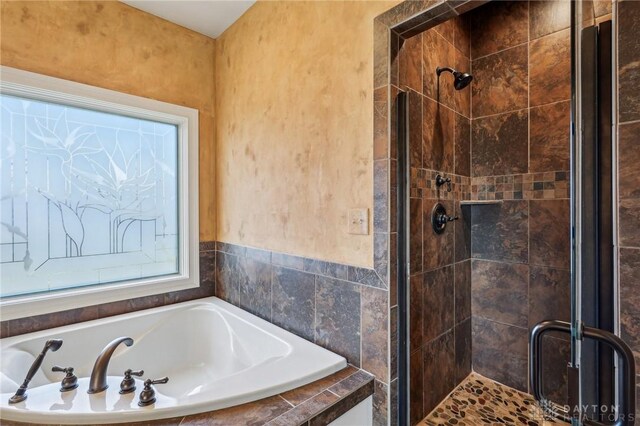 bathroom featuring shower with separate bathtub