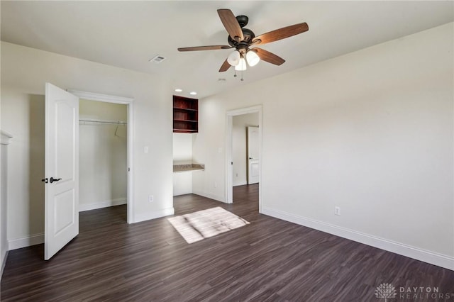 unfurnished bedroom featuring ceiling fan, dark hardwood / wood-style floors, and a closet