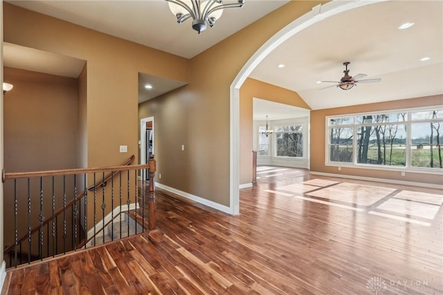 interior space featuring wood-type flooring, ceiling fan with notable chandelier, and vaulted ceiling