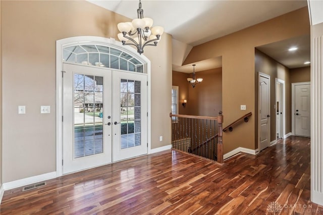 entryway with a notable chandelier, dark hardwood / wood-style floors, and french doors