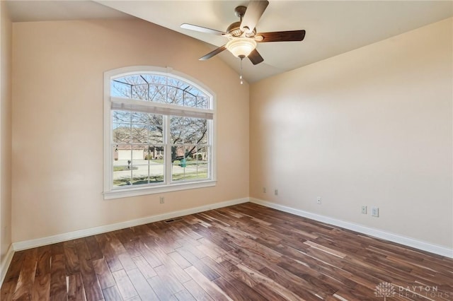 empty room featuring ceiling fan, dark hardwood / wood-style floors, and vaulted ceiling