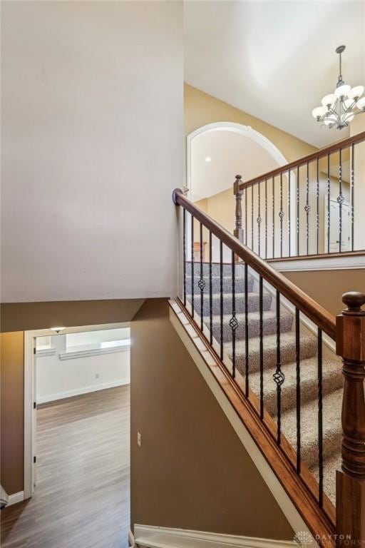 stairway featuring a chandelier and hardwood / wood-style flooring