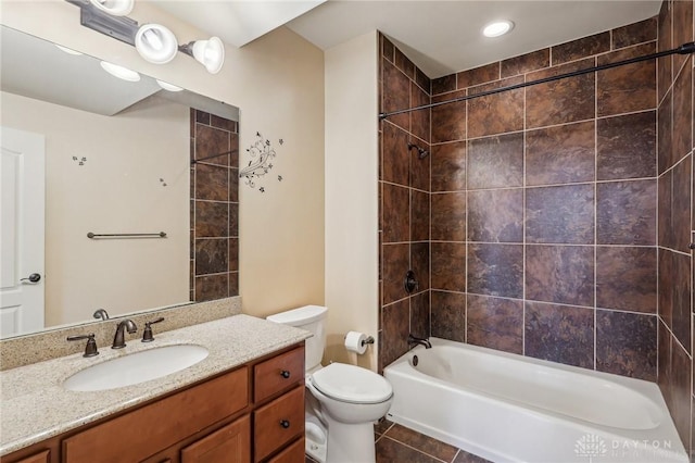 full bathroom with tiled shower / bath, tile patterned floors, vanity, and toilet