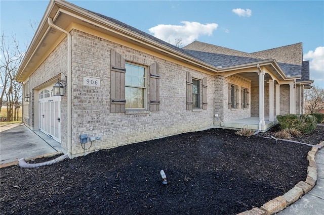 view of side of home featuring covered porch and a garage