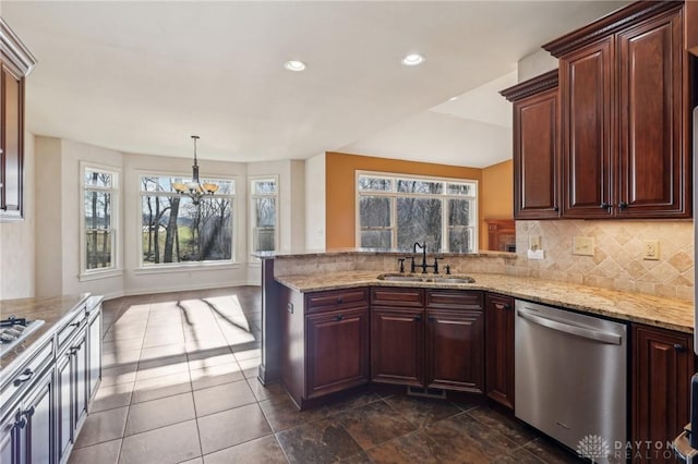 kitchen featuring backsplash, stainless steel appliances, sink, a chandelier, and hanging light fixtures