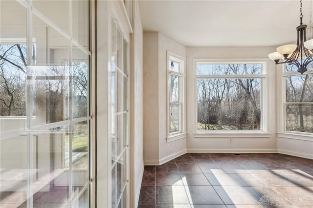 unfurnished sunroom featuring an inviting chandelier and plenty of natural light