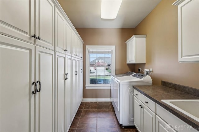 washroom with dark tile patterned flooring, cabinets, independent washer and dryer, and sink