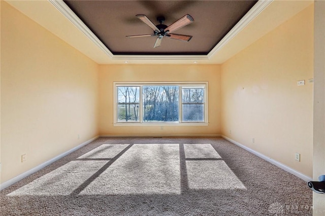 carpeted spare room featuring a tray ceiling and ceiling fan