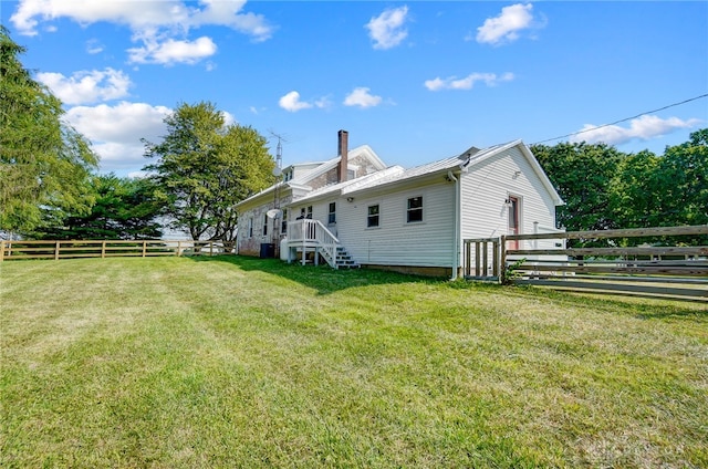 rear view of house featuring a lawn