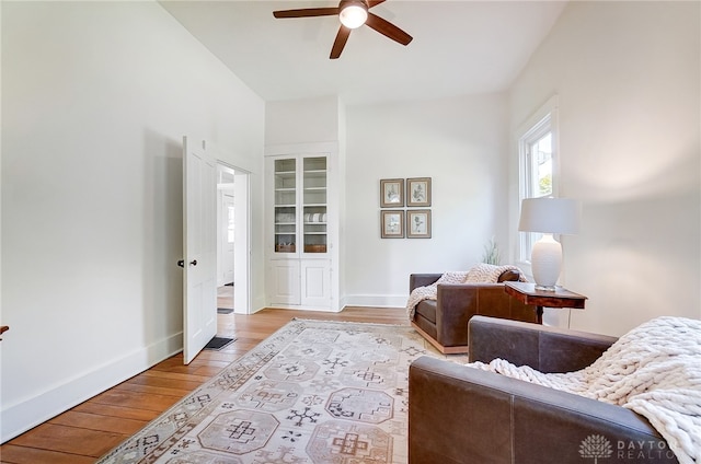 sitting room with light wood-type flooring and ceiling fan