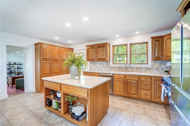 kitchen featuring backsplash, appliances with stainless steel finishes, sink, light tile patterned flooring, and a kitchen island