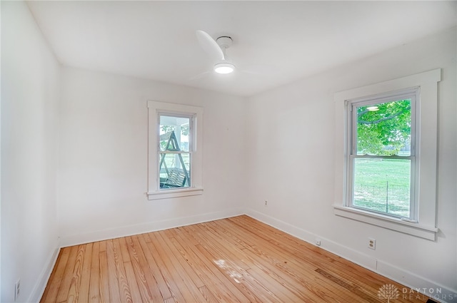 empty room with a wealth of natural light, ceiling fan, and light hardwood / wood-style floors