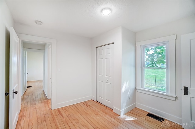 unfurnished bedroom featuring a closet and light wood-type flooring