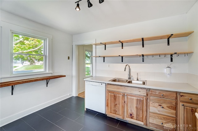 kitchen featuring dark tile patterned flooring, dishwasher, track lighting, and sink