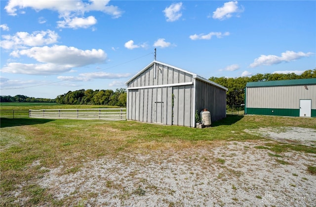 view of outdoor structure featuring a lawn and a rural view