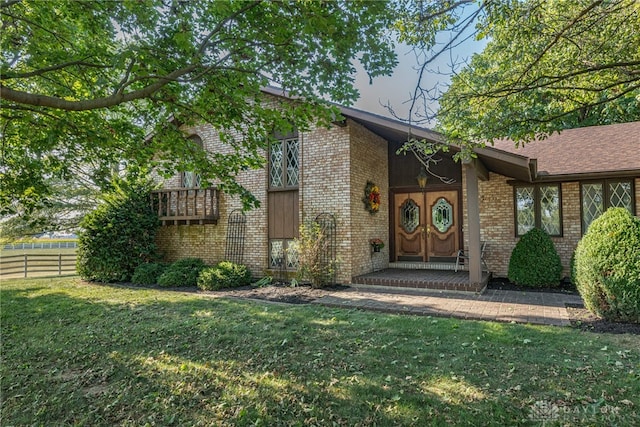 view of exterior entry with a yard