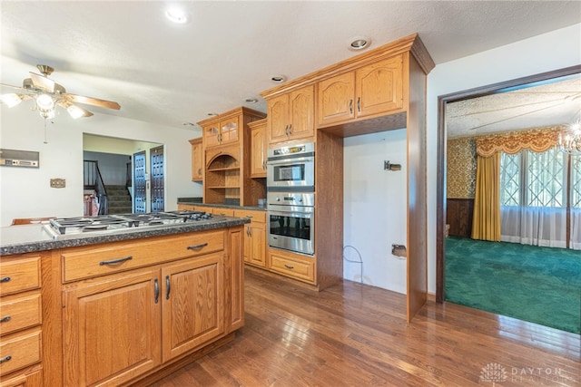 kitchen featuring stainless steel appliances, dark hardwood / wood-style floors, and ceiling fan