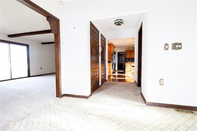 carpeted empty room with beamed ceiling