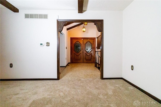 hall featuring beam ceiling and light colored carpet