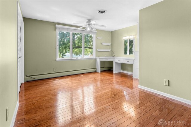 unfurnished living room with light wood-type flooring, ceiling fan, and baseboard heating