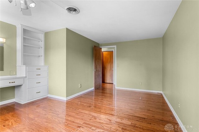 interior space featuring built in shelves and light hardwood / wood-style flooring