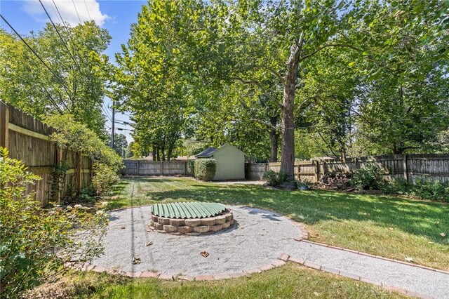 view of yard with a patio area, a fire pit, and a storage shed