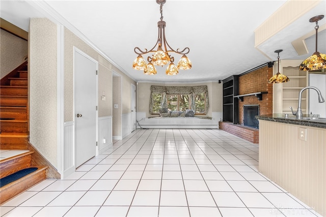 interior space with a fireplace, brick wall, light tile patterned flooring, and hanging light fixtures