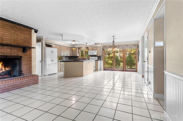 kitchen featuring light tile patterned floors, a brick fireplace, white appliances, decorative backsplash, and ornamental molding