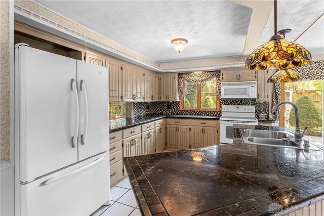 kitchen with white appliances, decorative backsplash, a textured ceiling, and sink