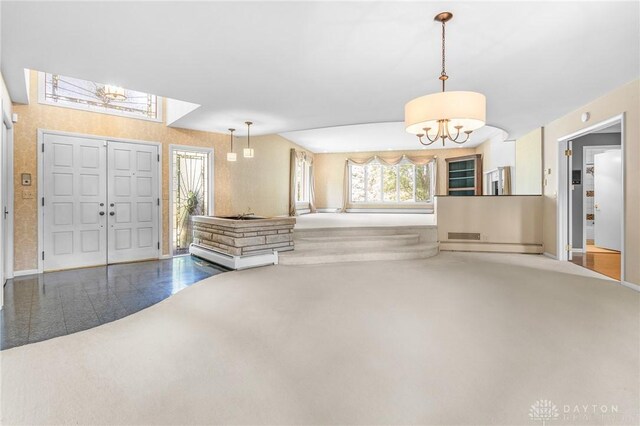 entrance foyer featuring wood-type flooring, a baseboard radiator, and an inviting chandelier