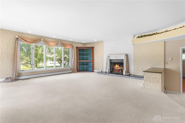 unfurnished living room featuring baseboard heating and carpet floors